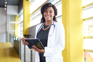 Physician smiling with clipboard containing notes about Healthcare Spending Account