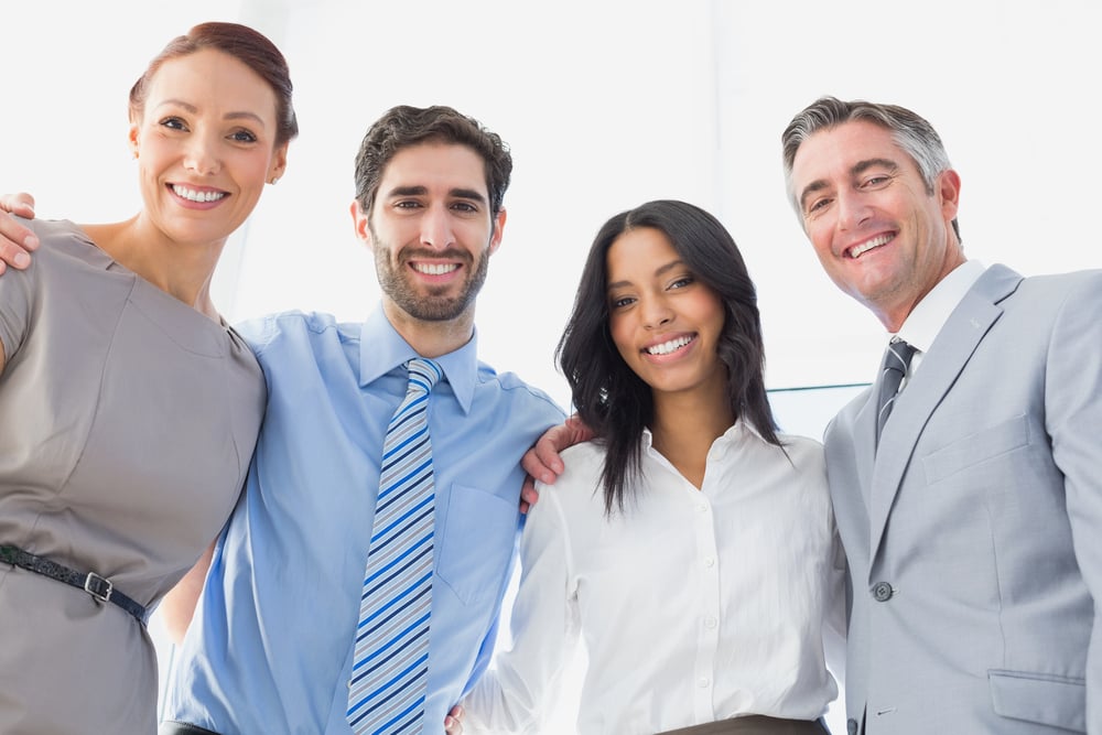 Smiling employees standing all together at work
