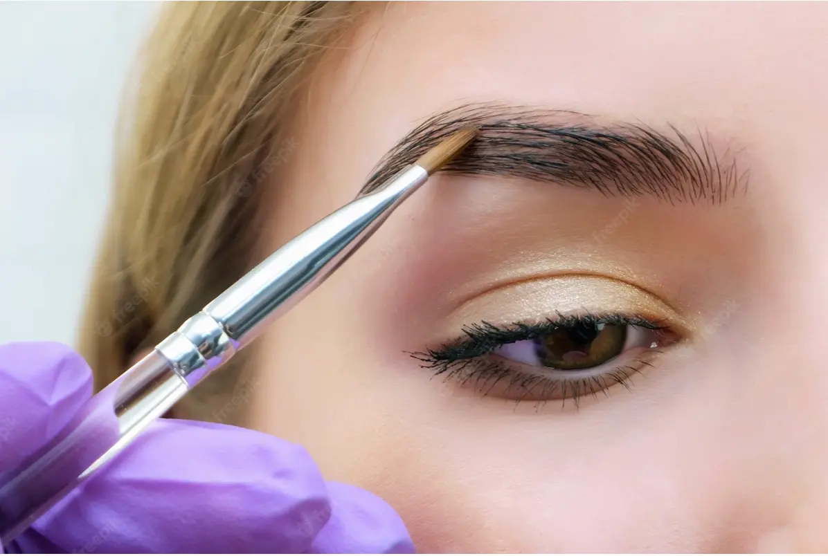 Woman with silver gray eyebrows microblading.